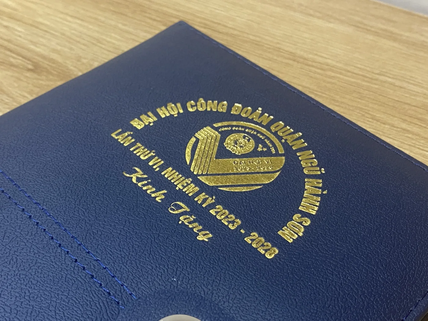 Cận cảnh biểu trưng m&agrave;u v&agrave;ng phản s&aacute;ng tr&ecirc;n b&igrave;a sổ xanh đậm