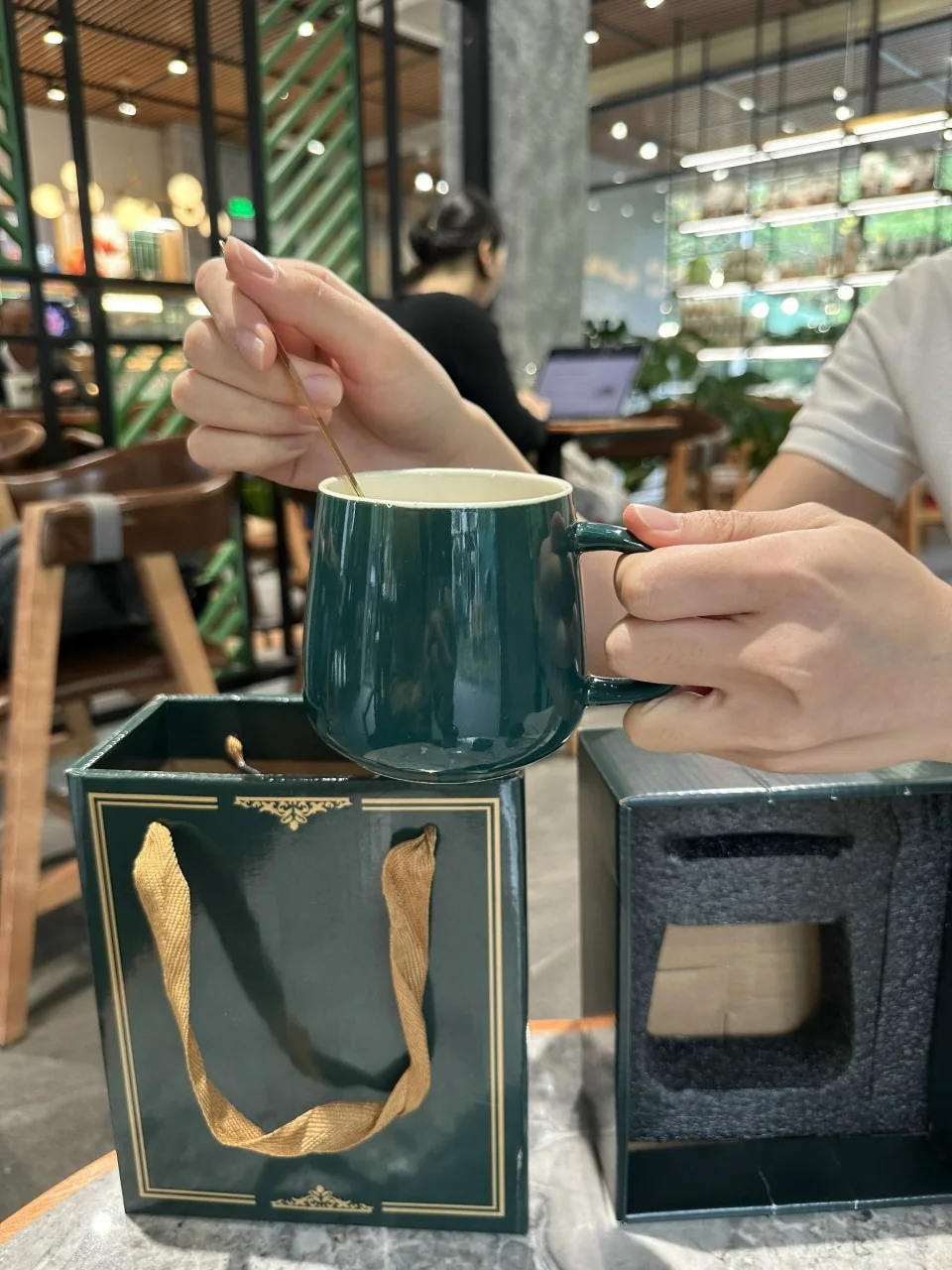 Người d&ugrave;ng cầm cốc c&oacute; logo để xem vị tr&iacute; in tiếp x&uacute;c với tay trong sinh hoạt.