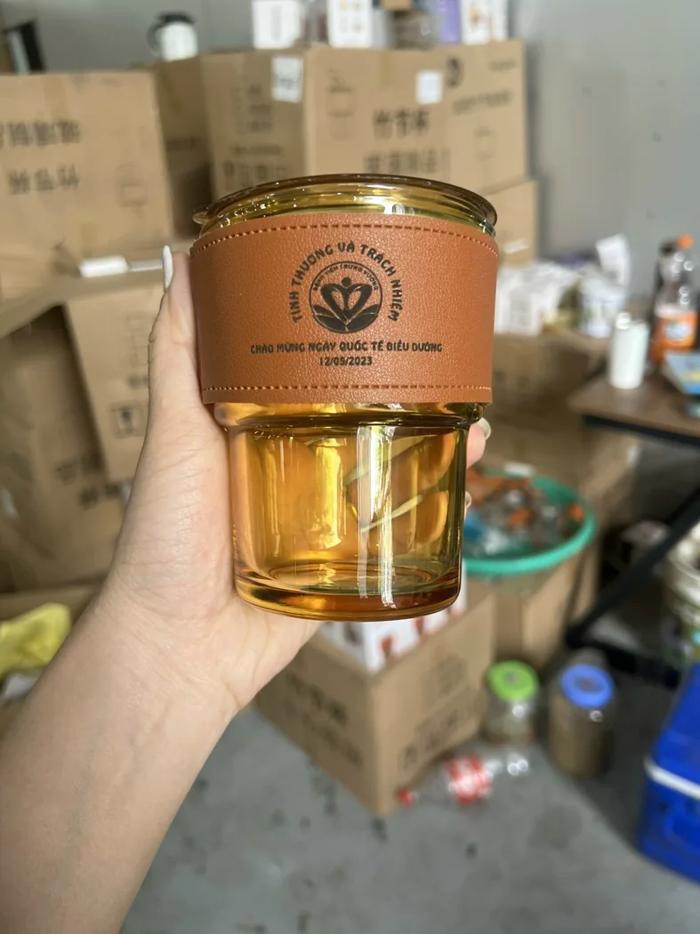 Ly trong suốt kh&ocirc;ng quai được cầm tr&ecirc;n tay, phần nhận diện nằm tr&ecirc;n v&ograve;ng bọc