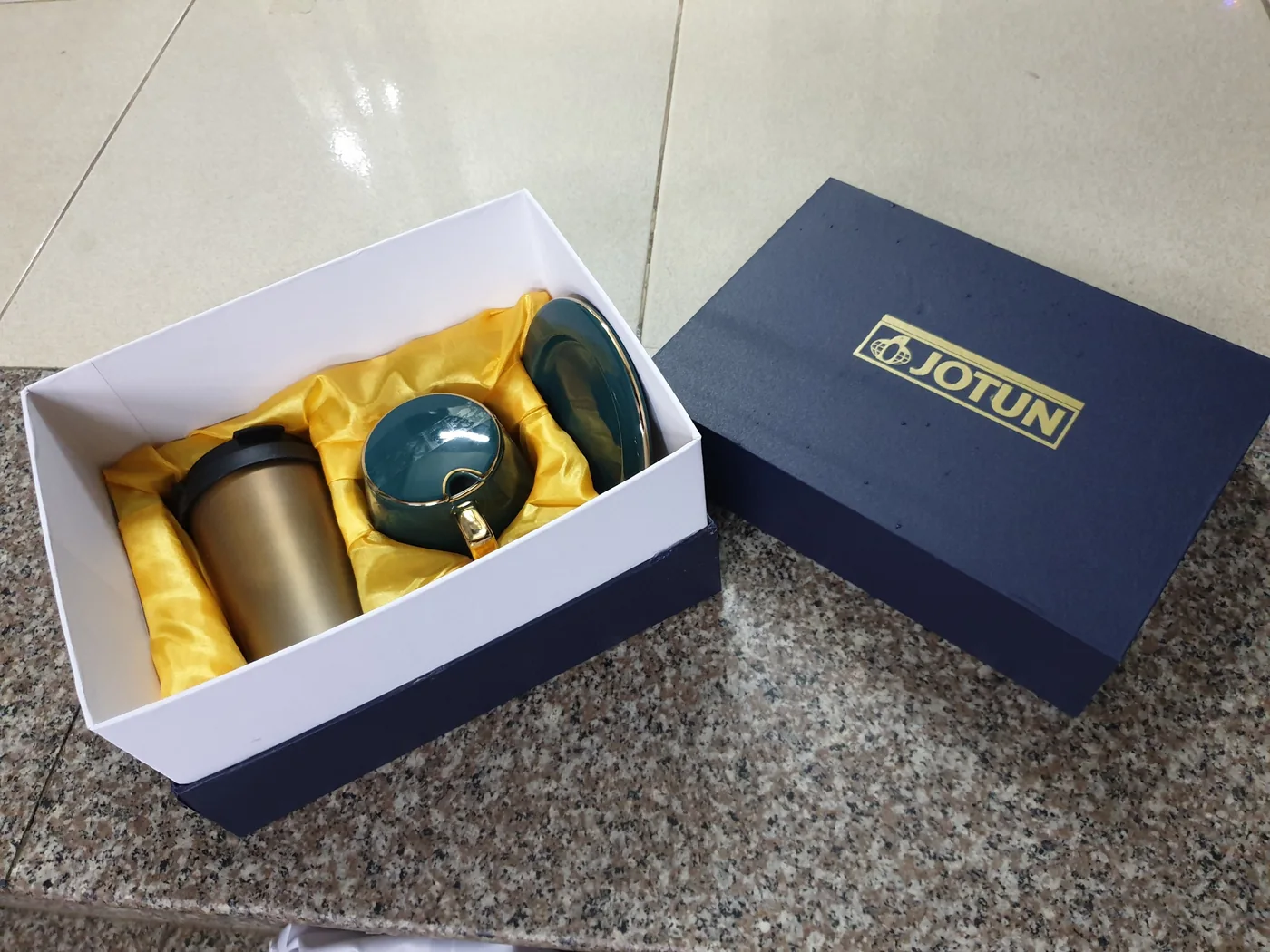 B&igrave;nh, cốc v&agrave; đĩa trong hộp xanh in JOTUN c&oacute; lớp l&oacute;t v&agrave;ng