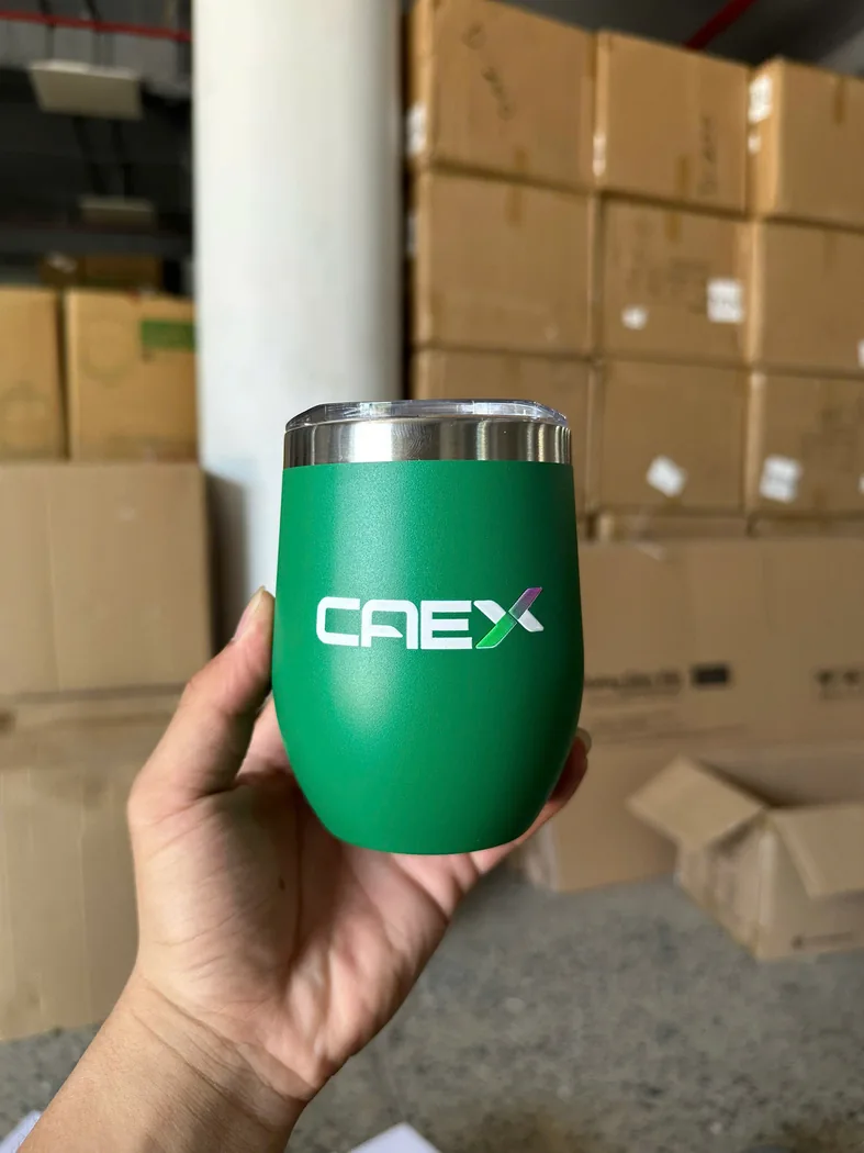 Cốc giữ nhiệt xanh in logo CAEX được cầm tr&ecirc;n tay
