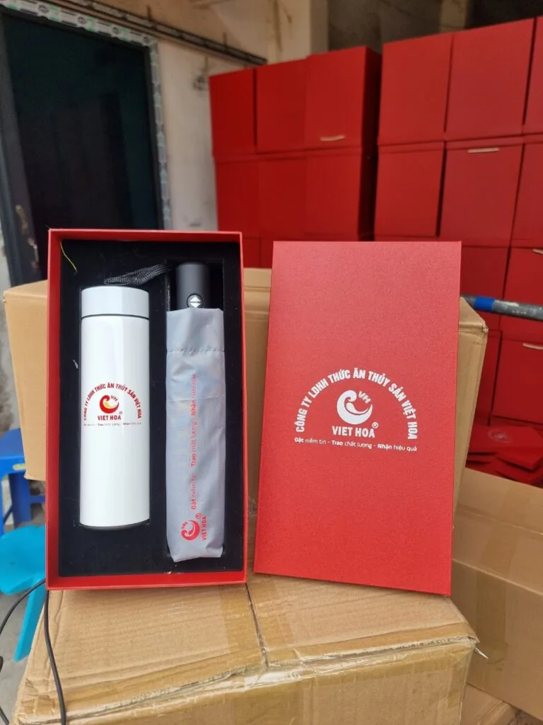 Bộ bình và ô in dấu sự kiện đặt trong hộp đỏ bên cạnh các thùng cùng mẫu