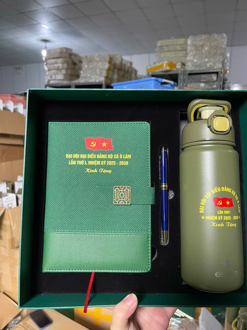 Hộp xanh chứa sổ, b&uacute;t v&agrave; b&igrave;nh in c&ugrave;ng nội dung đại hội