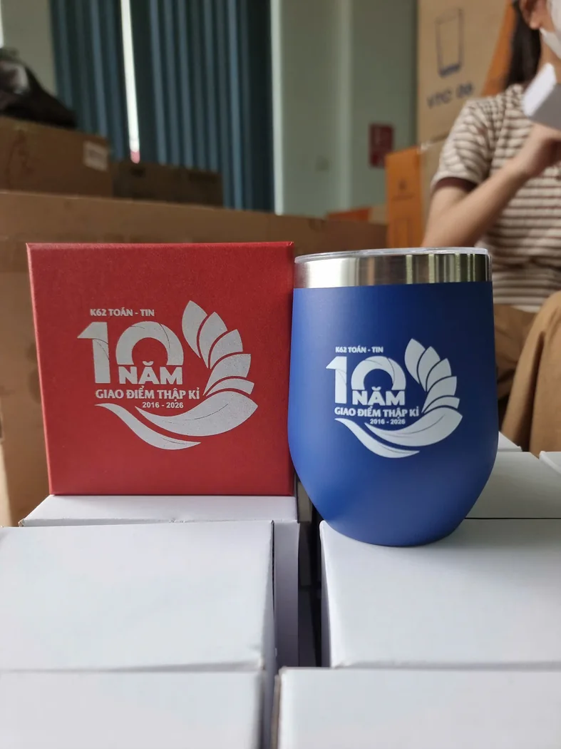 Ly m&agrave;u xanh in dấu đặt cạnh hộp qu&agrave; trong khu vực chuẩn bị h&agrave;ng