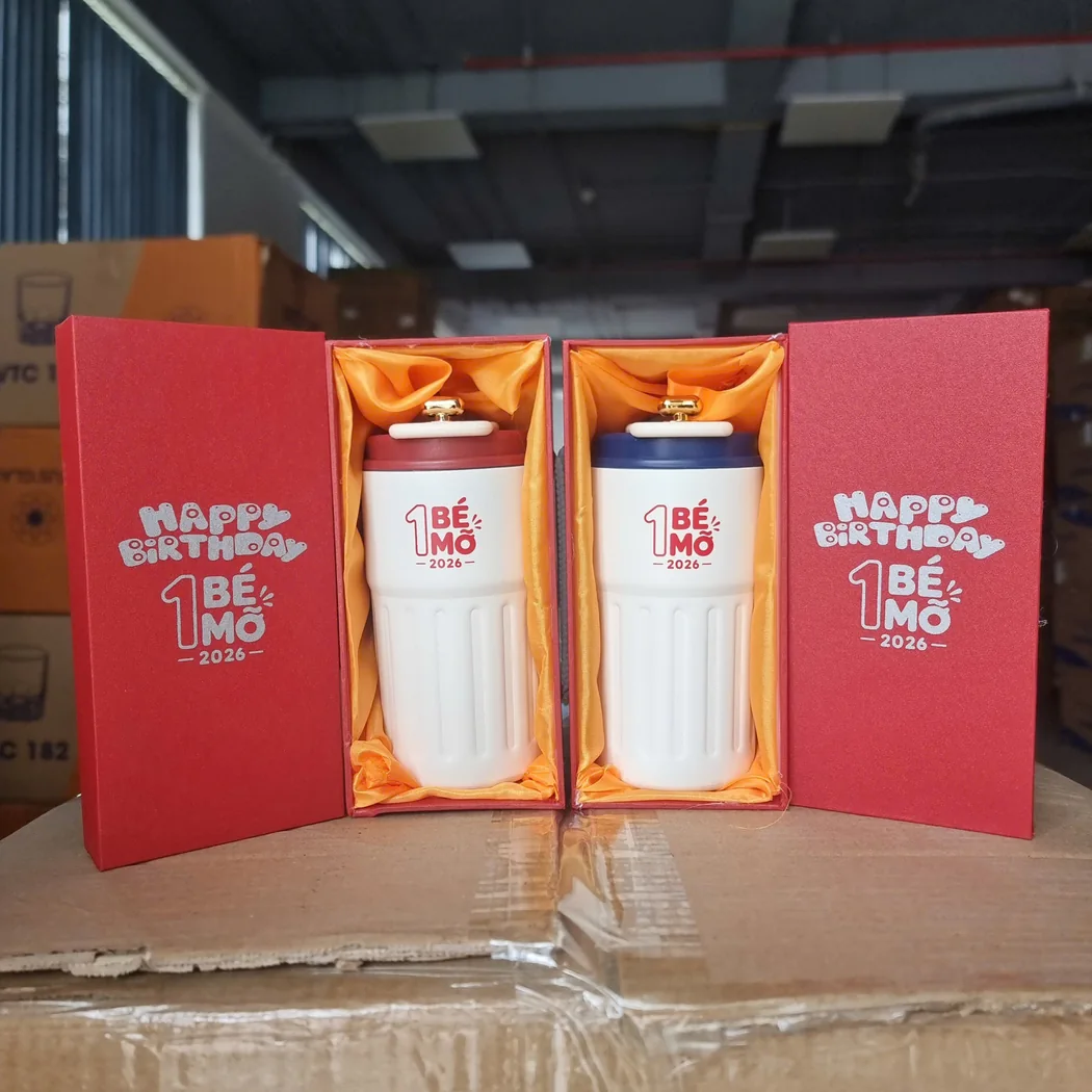 Hai cốc trắng in c&ugrave;ng dấu chương tr&igrave;nh nhưng nắp đỏ v&agrave; nắp xanh trong hai hộp ri&ecirc;ng
