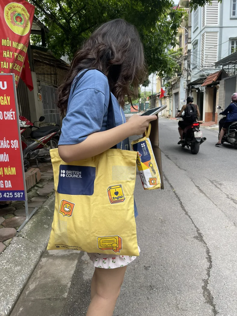 Người mang t&uacute;i vải in logo tr&ecirc;n vai khi đi ngo&agrave;i đường