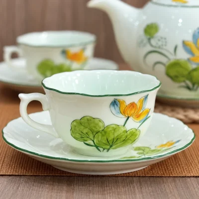 Góc cận chỉnh từ ảnh nguồn chén men ngọc sen vàng với quai và viền xanh