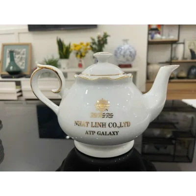 Ảnh tư liệu ấm thiên kim có viền màu vàng và chữ NHAT LINH CO LTD ATP GALAXY