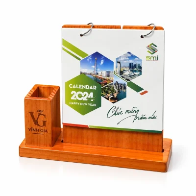 Lịch để bàn gỗ nâu cam kèm hộp bút bên trái – nhận diện khắc rõ trên hộp bút