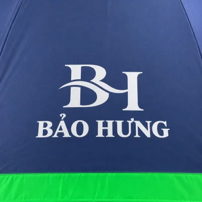 Ô dù golf cán thẳng hai tầng xanh đậm viền xanh lá – logo trắng rõ trong vùng tán xanh đậm