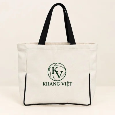 Demo KHANG VIỆT xanh lá với monogram KV trên túi canvas quai đen